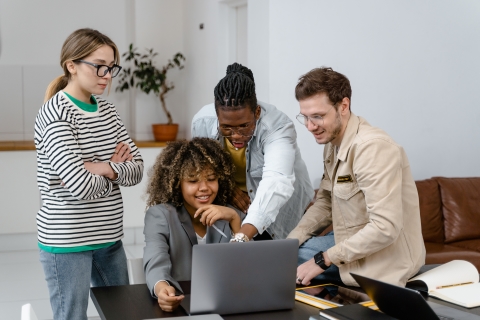 Colleagues working together around a laptop